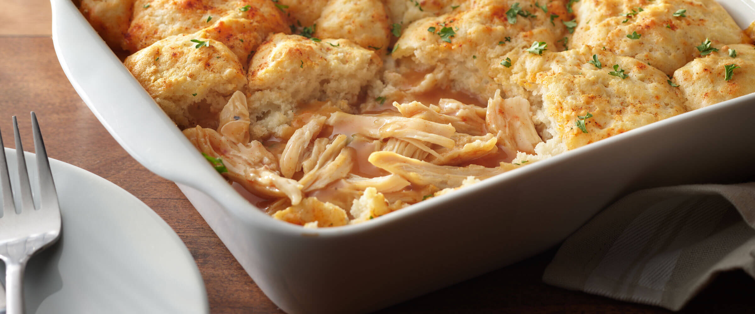 Chicken Biscuits and Gravy Casserole in white dish with fork