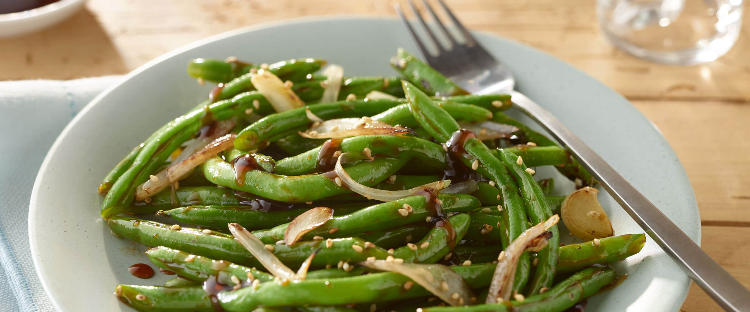 Asian Green Beans with sesame seeds in bowl with fork
