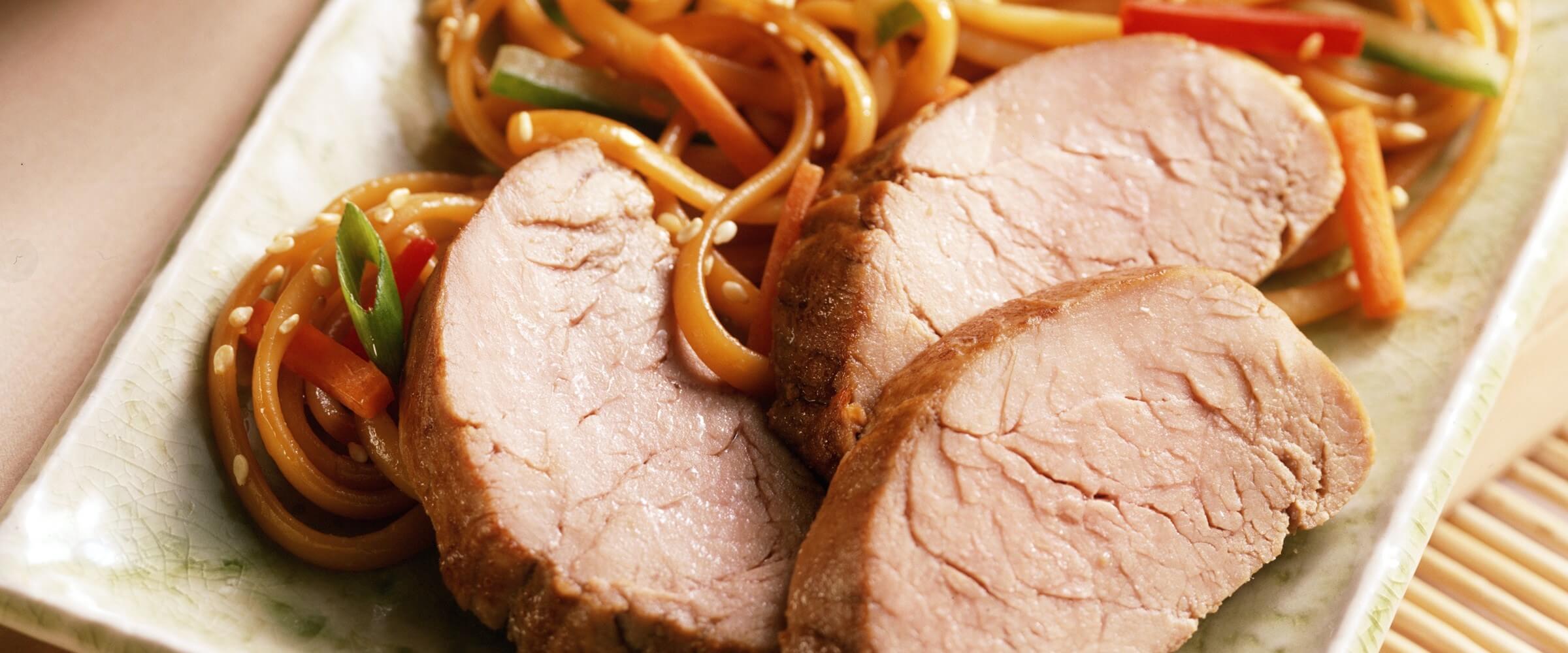 sesame spiced pork lo mein on plate with vegetables
