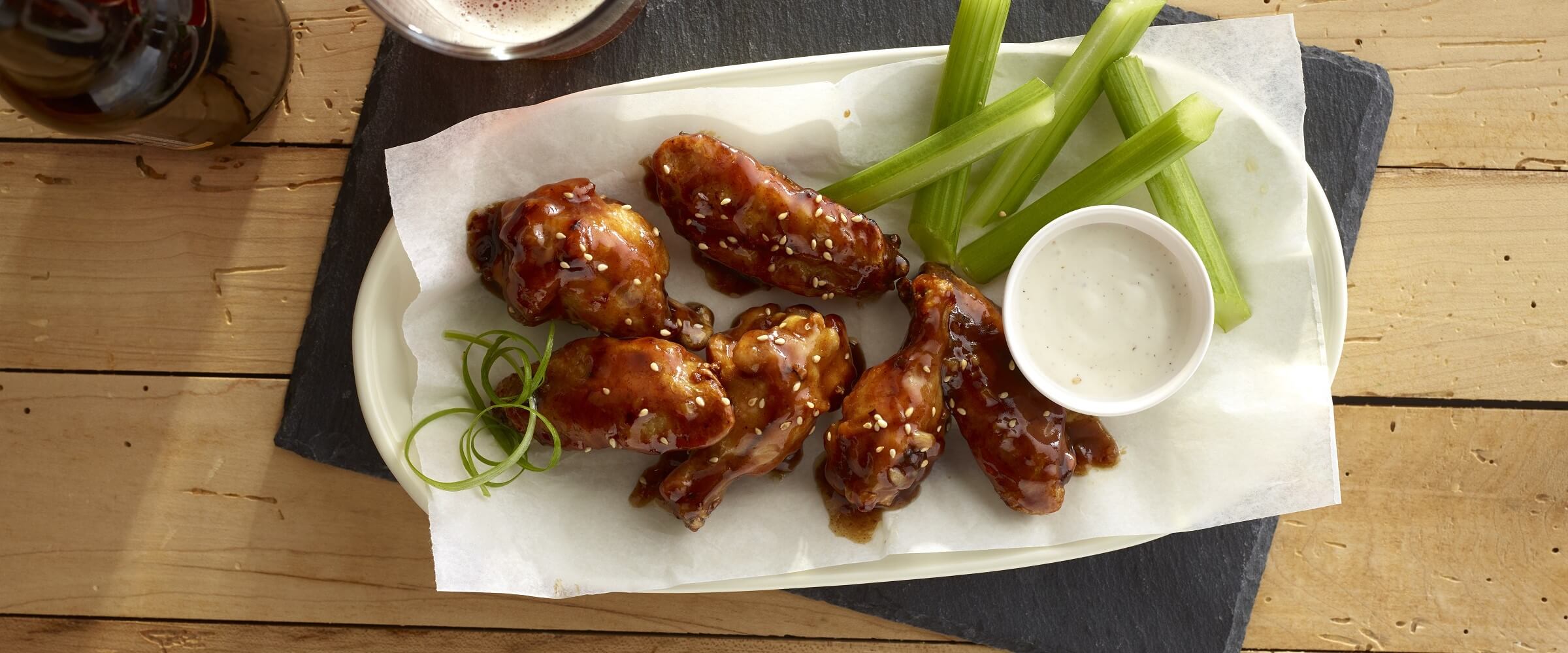 spicy szechuan hot wings in basket with celery and ranch dipping sauce