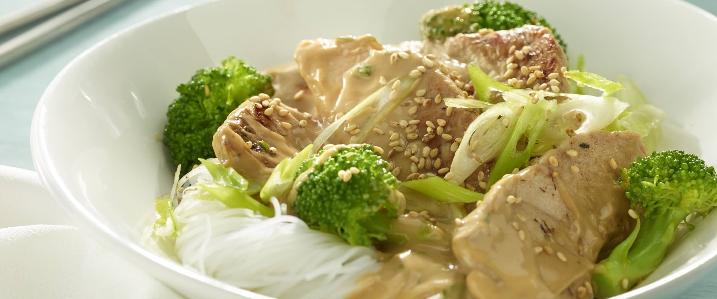 turkey peanut noodles with broccoli in white bowl