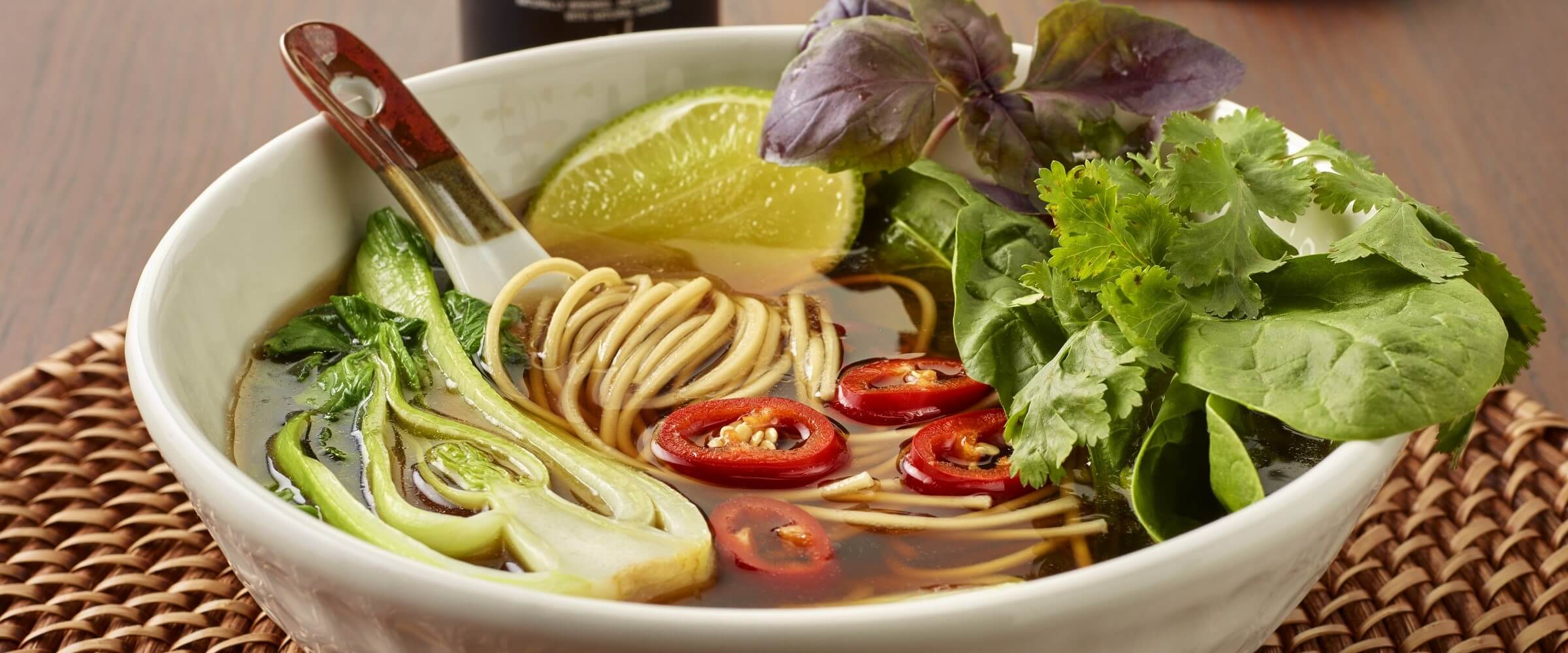 vegetable pho in cream bowl with garnish