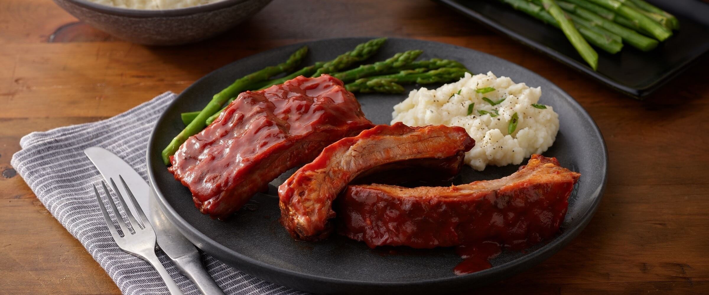 Microwave ribs with potatoes and asparagus on plate plate