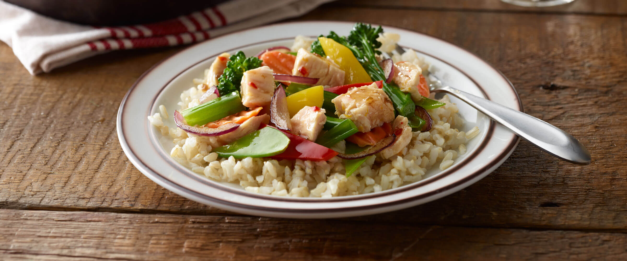 Citrus Chicken Stir-Fry over rice on plate with fork