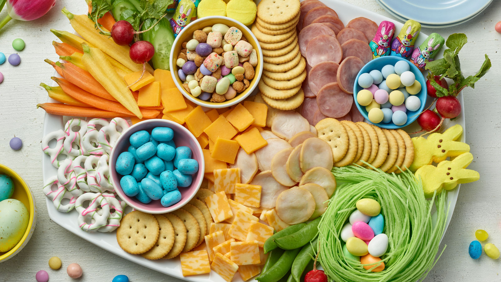 Close up of a ham and turkey party tray laid out with spring themed snacks